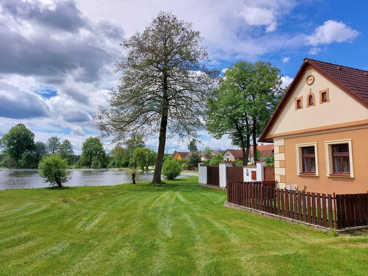 Pohled na Chalupu pod Choustníkem u rybníka v Kajetíně